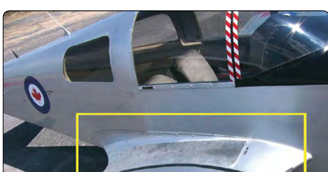 Photograph of a low-wing airplane's wing root with a smooth fairing blending the wing into the fuselage, highlighted by a rectangle