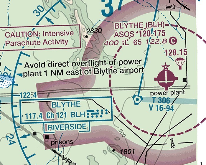 Sectional chart excerpt of Blythe Airport in the California desert. A dashed magenta arc curves around the airport symbol, marking a Class E surface area. A broad graded magenta band crosses the excerpt separately, marking the limit of a Class E floor at 700 feet AGL.