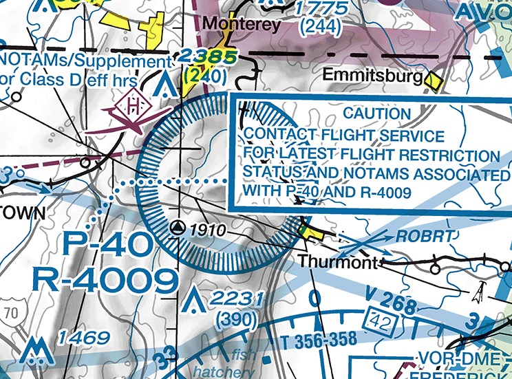 Sectional chart excerpt showing a circular airspace boundary northwest of Thurmont, Maryland, drawn as a blue line with a band of short blue ticks along its inside. The designations P-40 and R-4009 are printed in large blue type at the lower left of the circle, one above the other. To the right of the circle a blue-outlined box reads CAUTION, CONTACT FLIGHT SERVICE FOR LATEST FLIGHT RESTRICTION STATUS AND NOTAMS ASSOCIATED WITH P-40 AND R-4009. Emmitsburg lies above the box and Thurmont below it, with spot elevations and terrain contours around them.