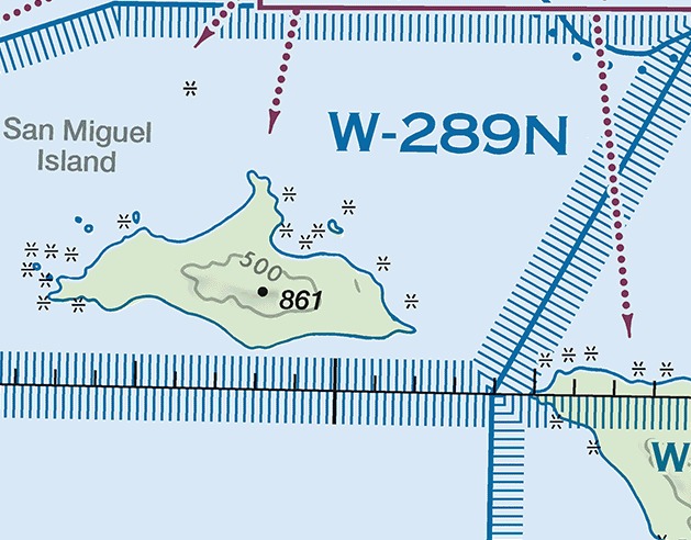 Sectional chart excerpt over the Pacific Ocean showing San Miguel Island. The designation W-289N is printed in large blue type across the upper part of the frame, right of center. Blue lines carrying bands of short blue ticks cross the frame in three places: along the top edge, diagonally down the right side, and horizontally below the island. A magenta line with its own band of ticks runs along the top edge right of center, and two magenta dotted lines carrying arrowheads descend through the frame. The island shows a 500-foot contour and a spot elevation of 861 feet.