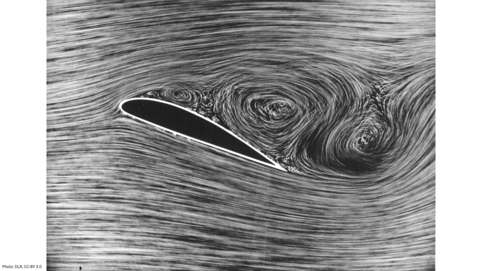 Wind-tunnel flow visualization of a stalled airfoil at high angle of attack: smooth streamlines ahead of the wing break into large turbulent vortices over and behind the upper surface