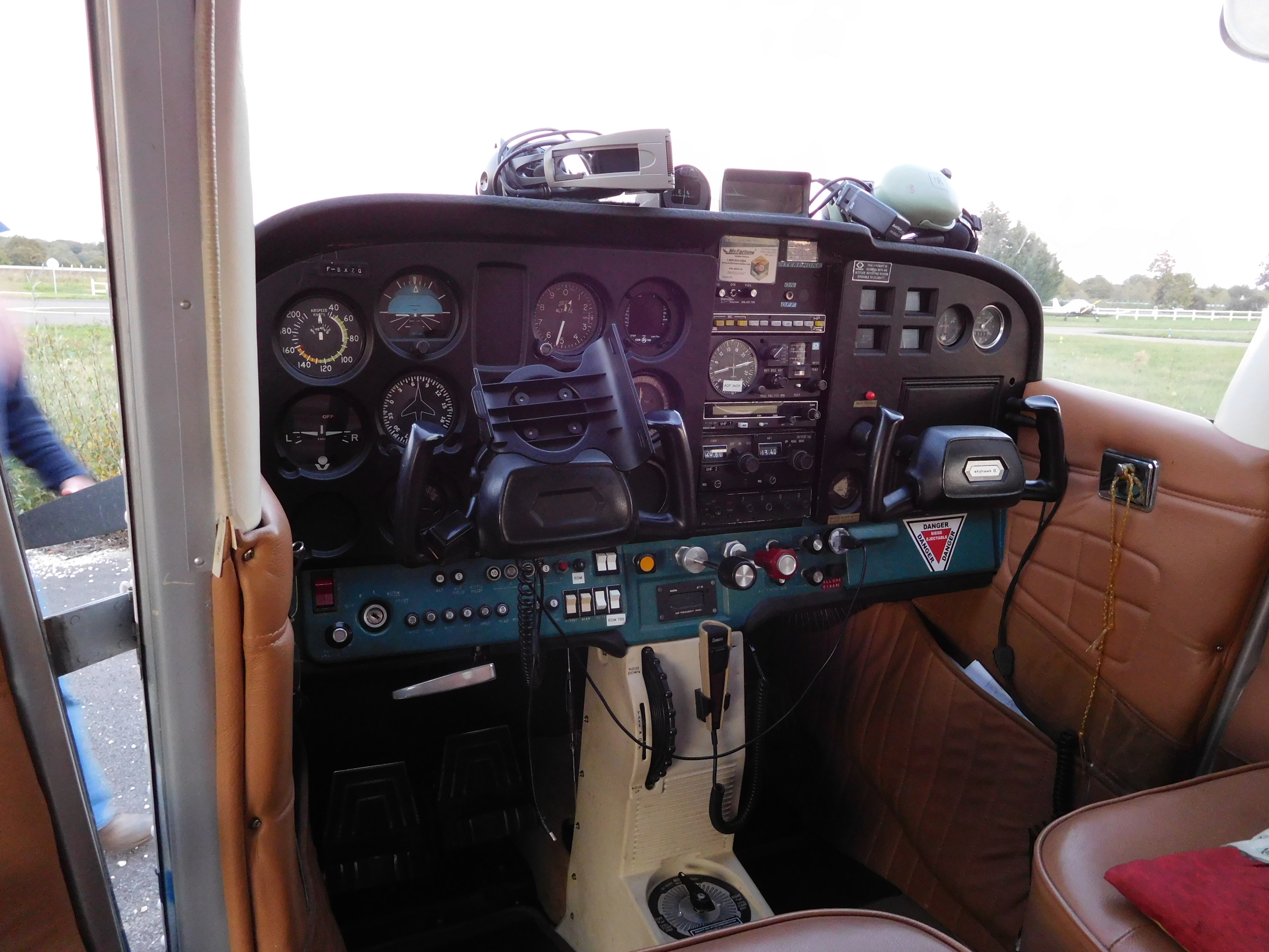 Lower panel of a Cessna 172 showing the throttle push knob and the red mixture knob